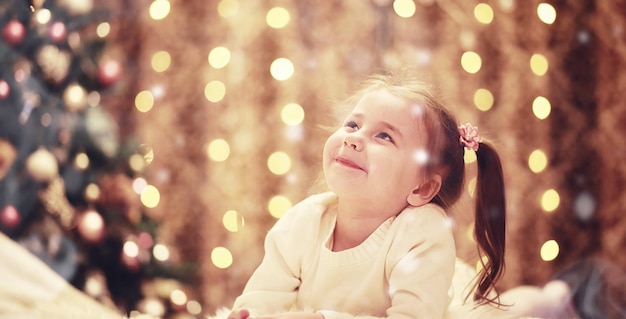 Famille la veille de Noël à la cheminée. Enfants ouvrant des cadeaux de Noël. Enfants sous l'arbre de Noël avec des coffrets cadeaux. Salon décoré avec cheminée traditionnelle. Soirée d'hiver chaleureuse et confortable à la maison.