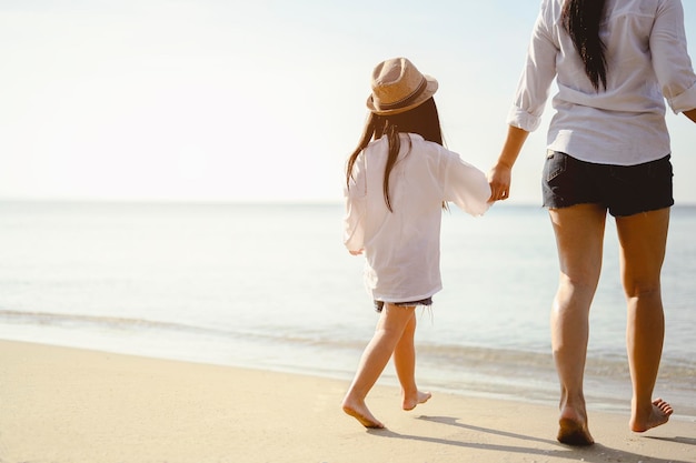 Famille, voyage, plage, détente, style de vie, concept de vacances. Mère et fille qui profitent d'un pique-nique et d'un bain de mer à la plage au coucher du soleil en vacances.