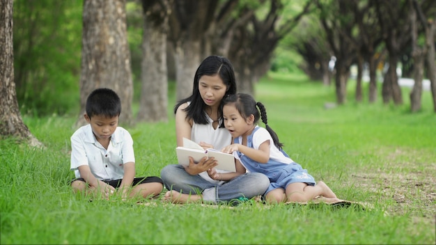 Des familles asiatiques font des activités ensemble en lisant des livres au parc avec joie