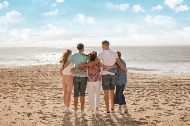 Des familles profitant d'une journée ensoleillée à la plage tout en appréciant ensemble la vue sur l'océan