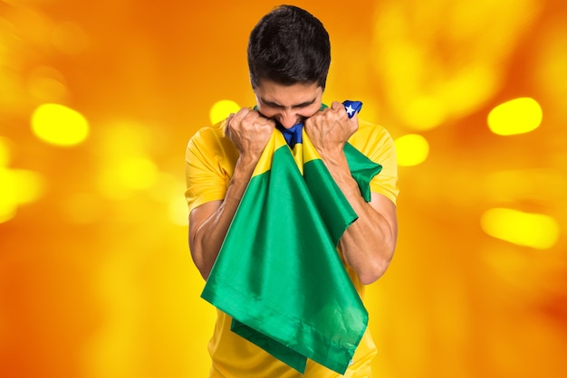 Fan brésilien célèbre sur fond jaune