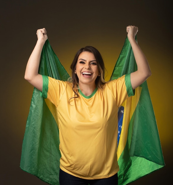 Fan brésilienne Fan brésilienne célébrant un match de football ou de football sur fond jaune Couleurs du Brésil