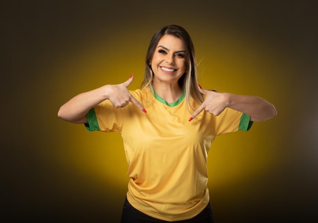 Fan brésilienne Fan brésilienne célébrant un match de football ou de football sur fond jaune Couleurs du Brésil