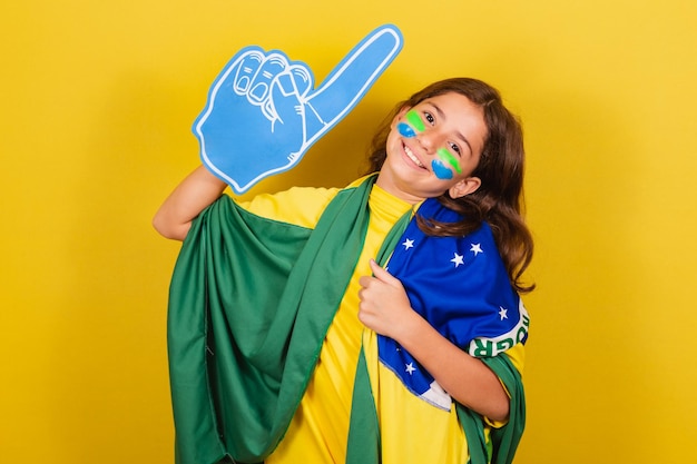 Fan de football enfant caucasien brésilien avec doigt en mousse célébrant et faisant la fête aux Jeux olympiques de la Coupe du monde