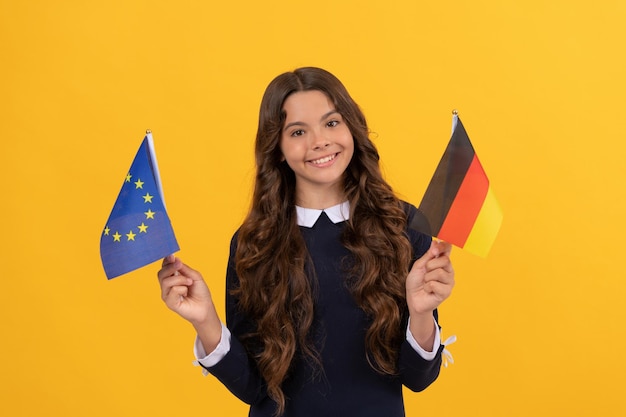 Fan de football enfant heureux titulaire d'un visa touristique de l'union européenne et du drapeau allemand dans le pays Schengen enfant fille voyage et étudie à l'étranger allemagne éducation de vacances dans une école étrangère