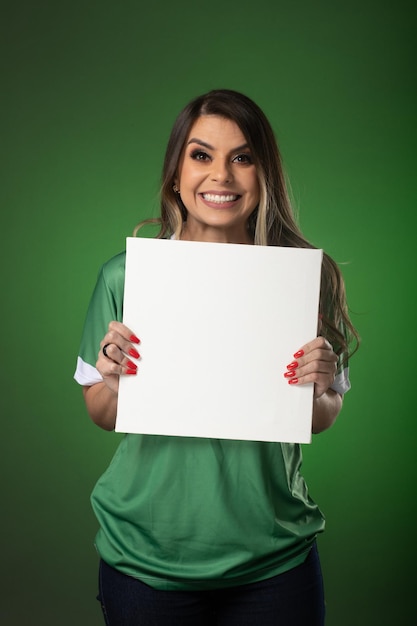 Fan de football femme acclamant son club préféré et l'équipe coupe du monde fond vert Holding White Blank Card