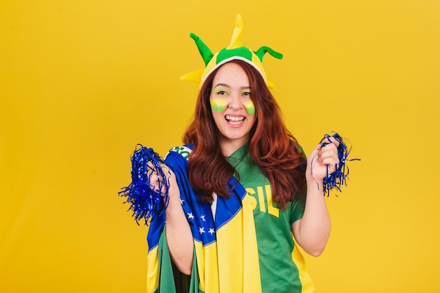 Fan de football femme rousse caucasienne du brésil dansant portant des pompons de pom-pom girl
