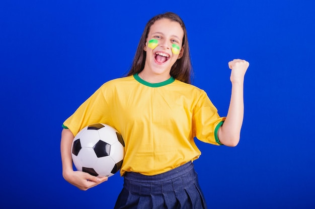 Fan de football de jeune fille du Brésil tenant le ballon de football