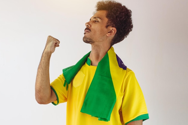 Fan de l'homme noir brésilien avec maillot de l'équipe de football isolé sur blanc