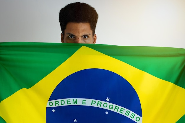 Fan de l'homme noir brésilien avec maillot de l'équipe de football isolé sur blanc