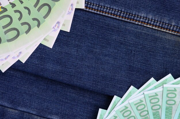 Les fans de beaucoup de billets en euros sont sur une surface en denim sombre. Image de fond