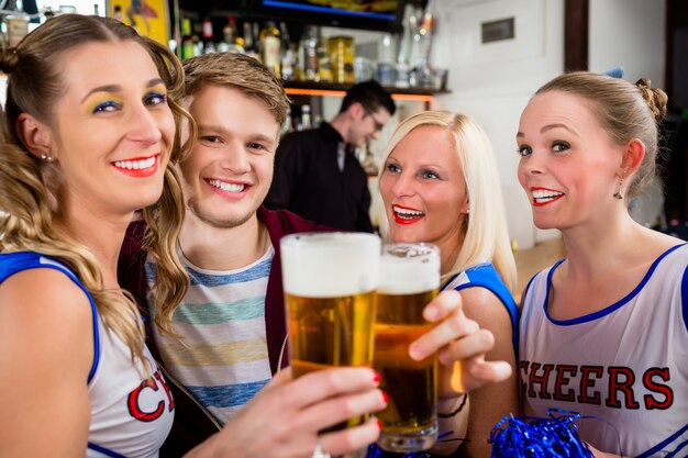 Fans d&#39;une équipe sportive en train de regarder un match au bar