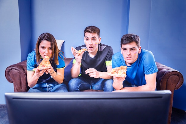 Photo les fans de football sur le canapé en regardant la télévision