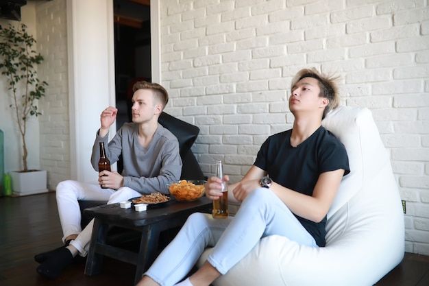 Les fans de football regardent le match et boivent de la bière à l'intérieur