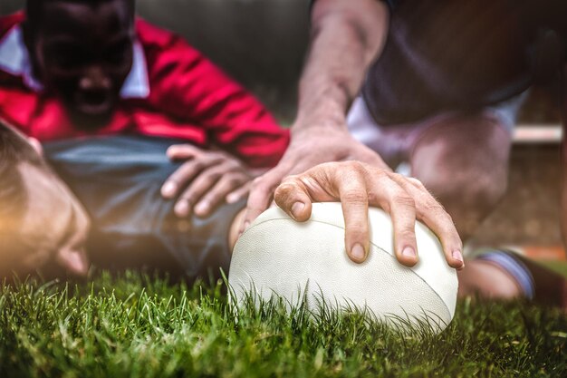 Fans de rugby dans l'arène contre un joueur de rugby marquant un essai