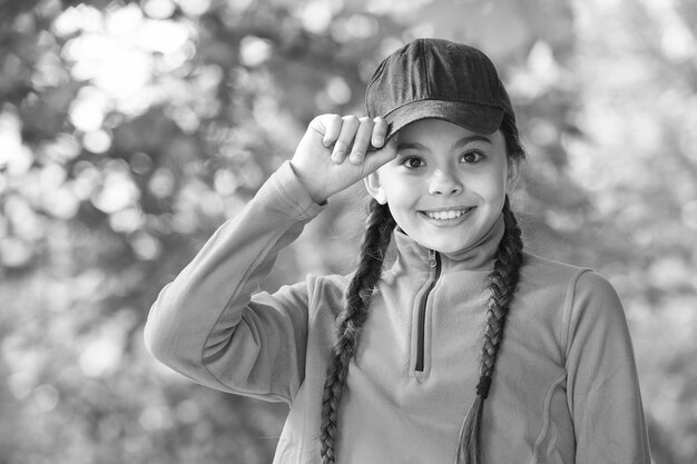 Fantastique touche finale à votre tenue hipster Petite fille porte une casquette hipster à l'extérieur Accessoire de mode Enfant heureux apprécie le style hipster Look beauté d'un petit enfant Style décontracté Tendance élégante