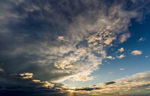 Fantastique vue panoramique de gris blanc gris foncé de larges nuages gonflés éclairés par le soleil se propageant contre le ciel bleu profond se déplaçant avec le vent. Beauté et puissance de la nature, météorologie et concept de changement climatique.