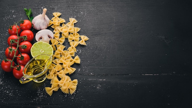 Farfalle de pâtes sèches aux légumes Sur un fond en bois Vue de dessus Espace de copie