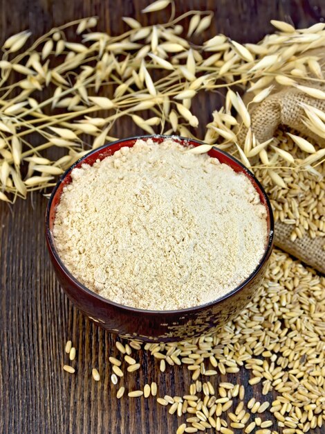 Farine d'avoine dans un bol avec grain à bord