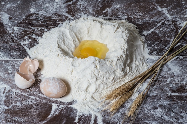 Farine blanche et oeufs isolés sur fond blanc