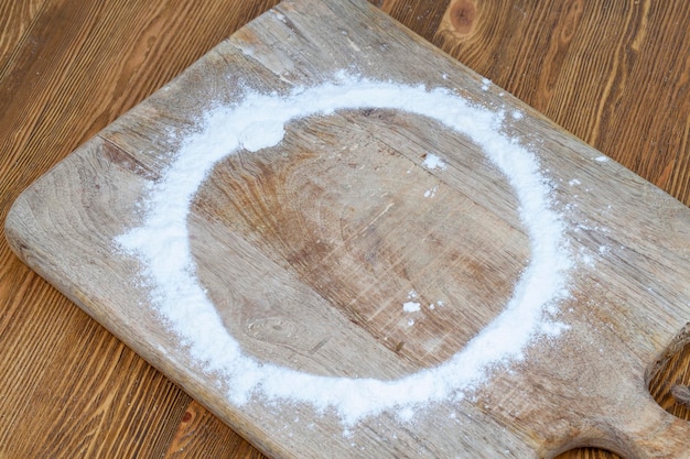 Farine de blé blanche éparpillée sur la table pendant la cuisson