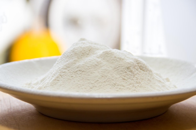 Farine de blé dans une assiette en porcelaine blanche sur la table