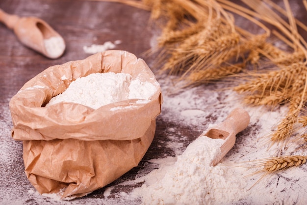 Farine dans un sac et une cuillère en bois