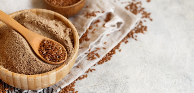 Farine de graines de lin crues dans un bol en bois avec une cuillère