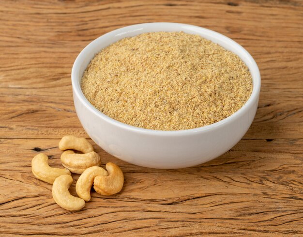 Farine de noix de cajou dans un bol sur une table en bois. Farine sans gluten.