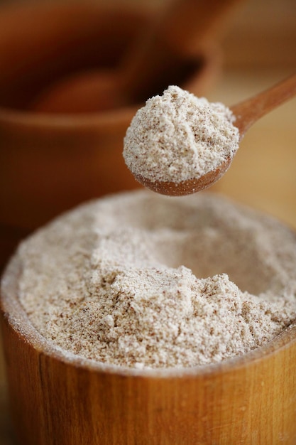 Farine de noix dans une cuillère sur une table et dans une planche de bois