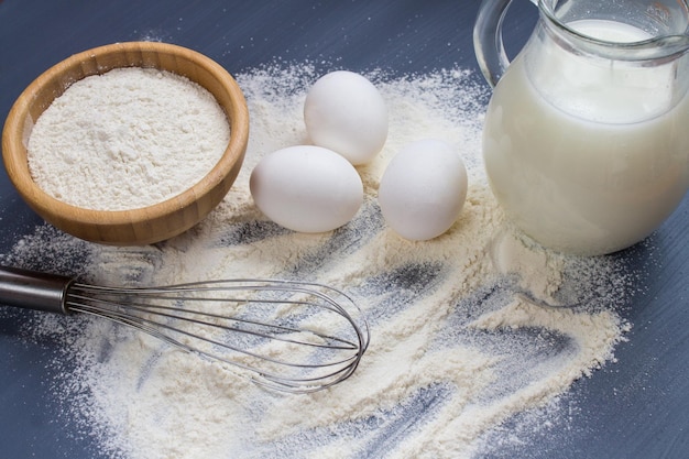 Farine d'oeufs et lait sur fond gris