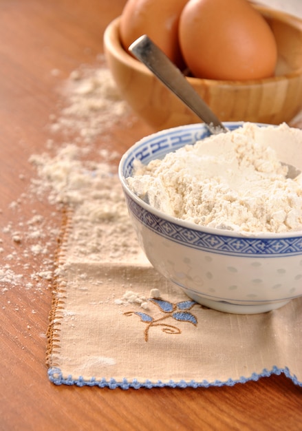 Farine, oeufs et lait sur une table en bois