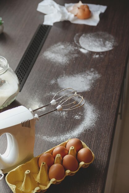 Farine d'oeufs et mélangeur dans la cuisine à domicile pour faire des tartes et des desserts pour la famille