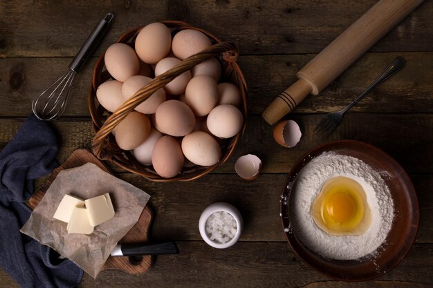 farine d'œufs de poulet brisés beurre et farce sur une table en bois