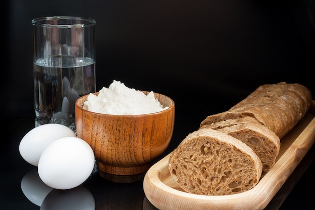 Farine, œufs, verre d&#39;eau avec baguette fraîche