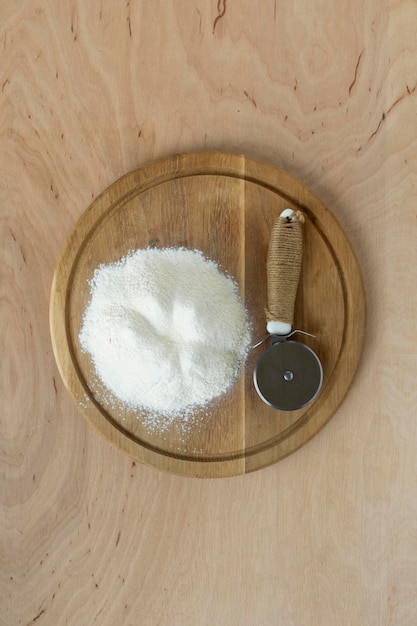 Farine sur planche à découper et fond de table en bois