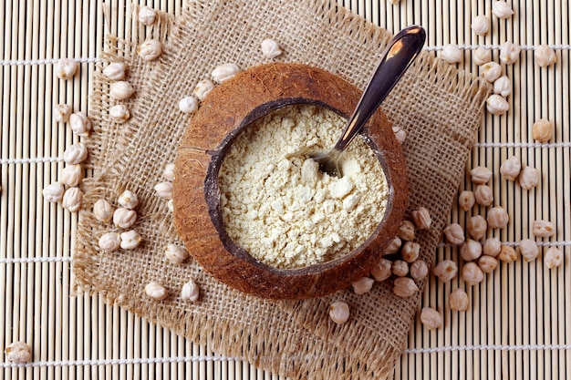 Farine de pois chiche biologique dans un bol sur une table en bois rustique sans gluten