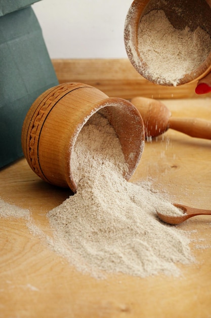 Farine de sésame blanc sain sur table en bois