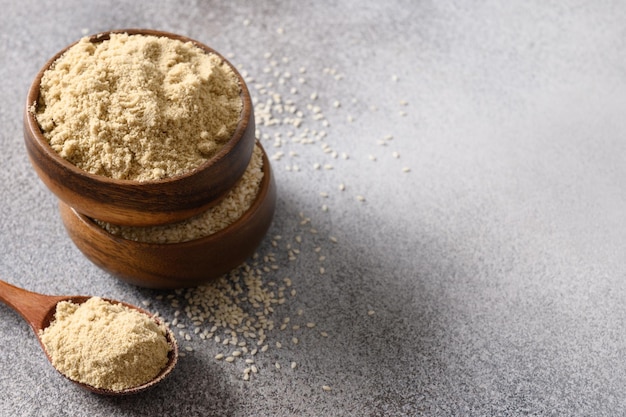 Farine de sésame dans un bol pour cuisiner un dessert végétalien sans gluten