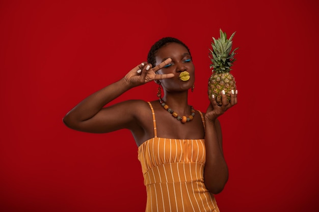 Fashionista dame noire émotionnelle avec ananas sur rouge
