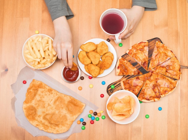 Fast food malbouffe concept Teen boy eating nuggets pizza chips et autres fast food