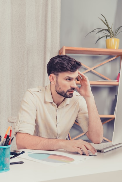 Fatigué bel homme ayant une dure journée au bureau