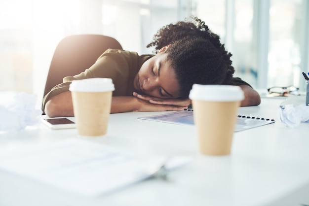 Fatigué de dormir et femme d'affaires sur le bureau avec le stress de la fatigue et épuisé de travailler au bureau Burnout surmené et paresseux Travailleur africain submergé par la charge de travail et la pression des délais