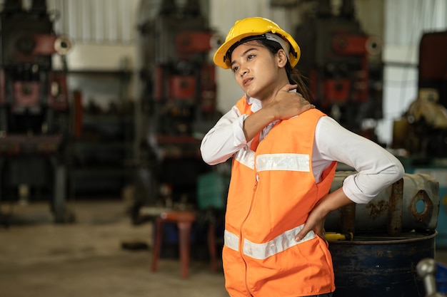 Fatigué des femmes de stress au cou des travailleuses travaillant dans une usine de l'industrie lourde, problème de santé concept de travail asiatique.