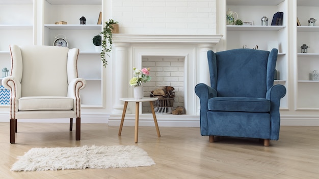 Fauteuil blanc et bleu avec table moderne blanche en face de la cheminée dans le salon