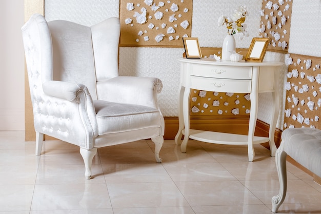 Photo fauteuil blanc luxueux et meubles anciens sculptés dans le salon
