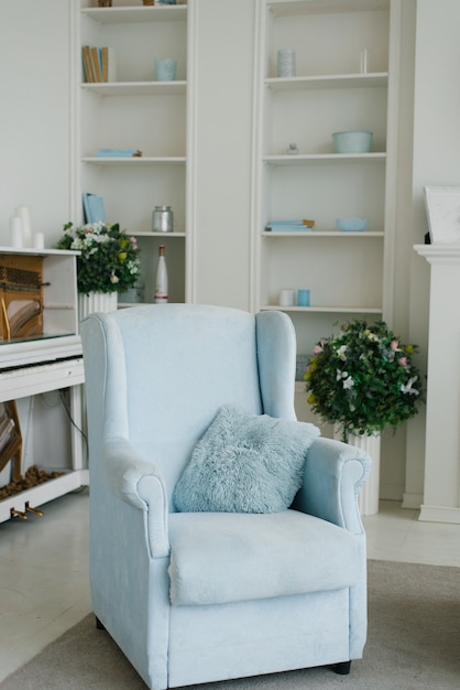 fauteuil bleu dans un salon blanc, intérieur classique de la maison