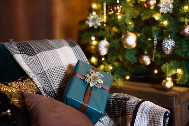 Fauteuil avec carreaux à carreaux et cadeau de Noël sur fond de carte de Noël sapin de Noël