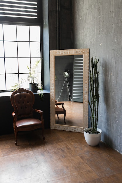 Fauteuil avec miroir vintage dans un intérieur de style loft