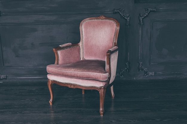 Photo fauteuil rose vintage dans une pièce sombre loft